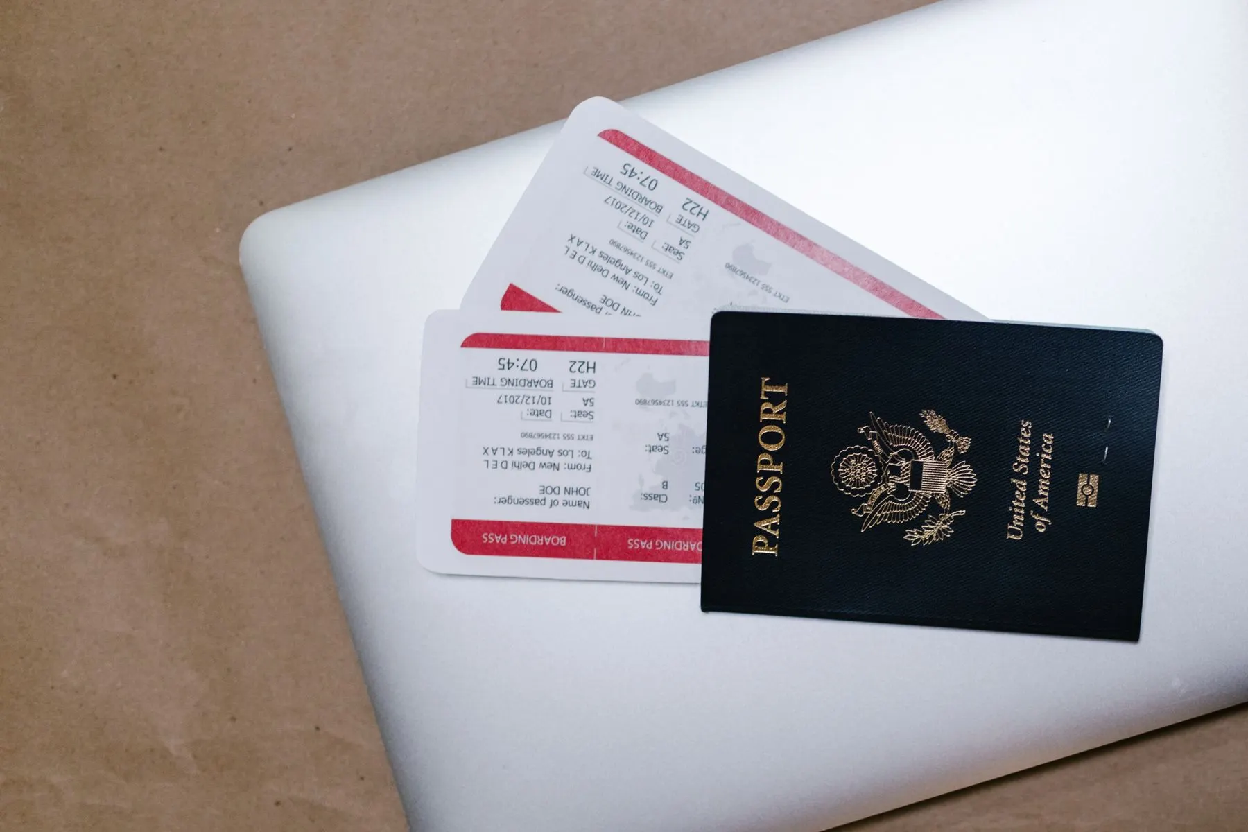 Passport and boarding passes arranged on a laptop before departure