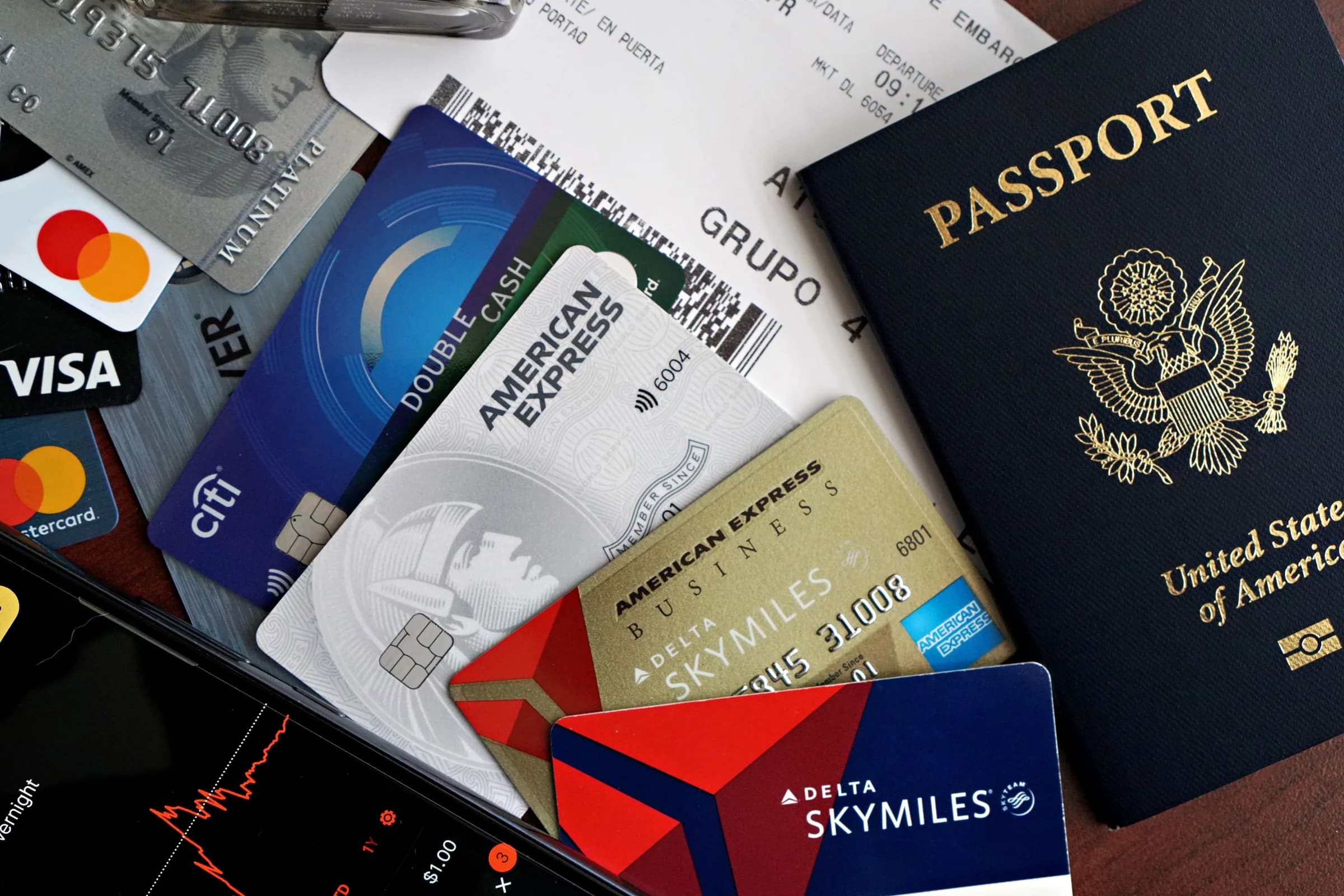 Passport, boarding pass and several physical payment cards prepared for travel