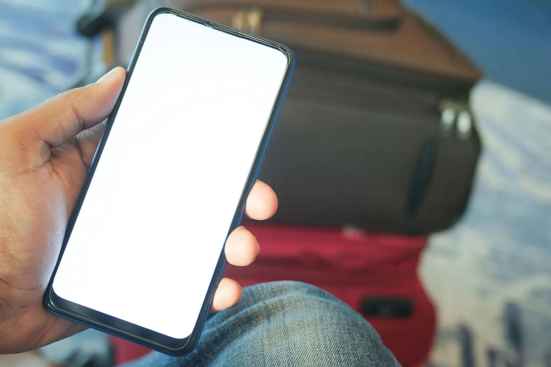 Smartphone held beside airport luggage during connectivity setup