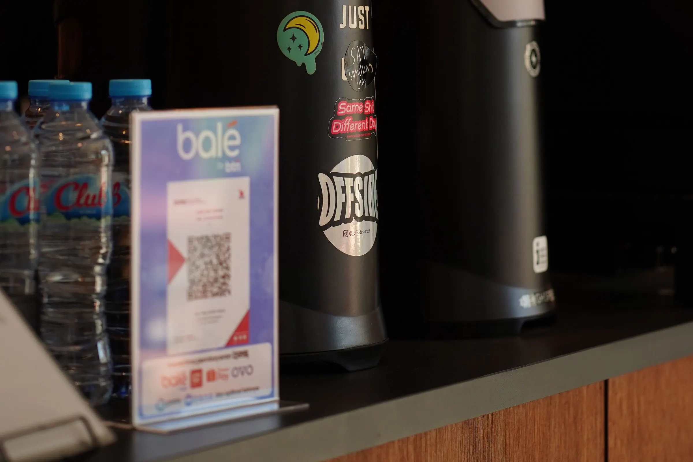 Merchant QR payment sign displayed at a cafe counter