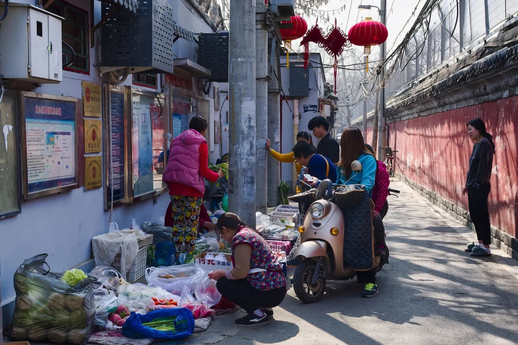 Local market stalls and shoppers in a Beijing hutong