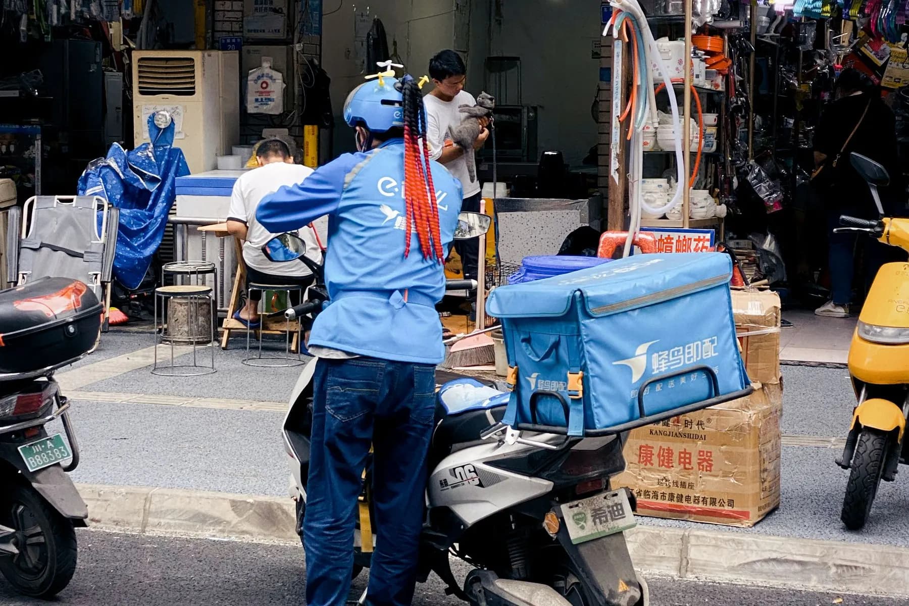Delivery rider and local shops on a Chengdu street