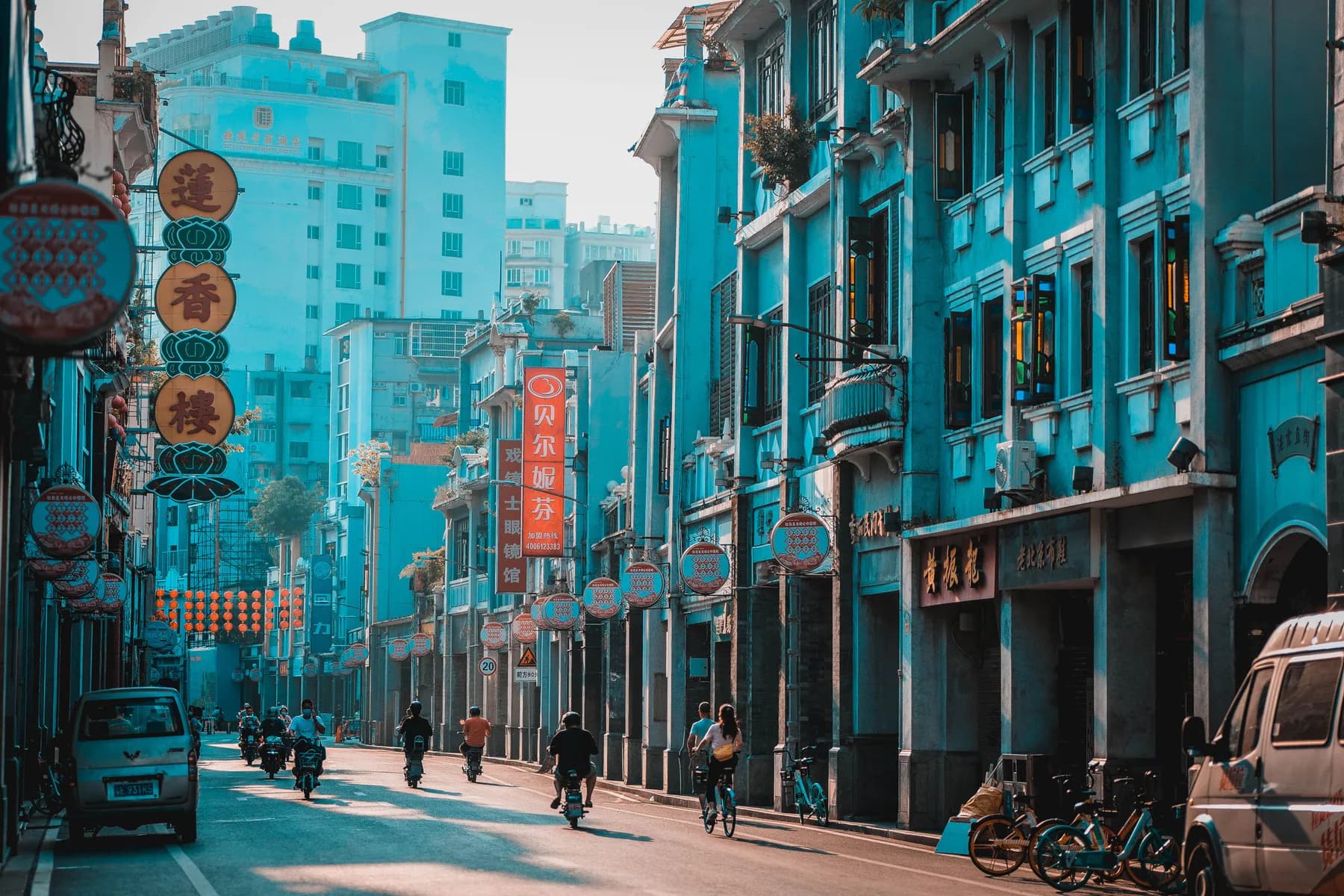 Cyclists and pedestrians moving through a heritage street in Guangzhou