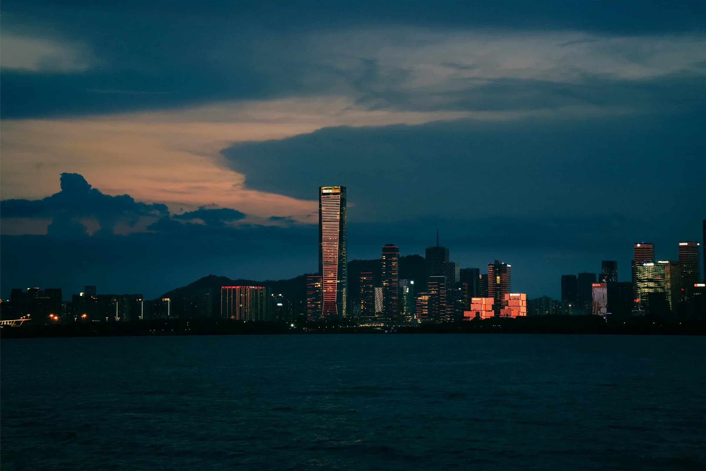 Shenzhen Bay skyline at twilight beneath dramatic clouds