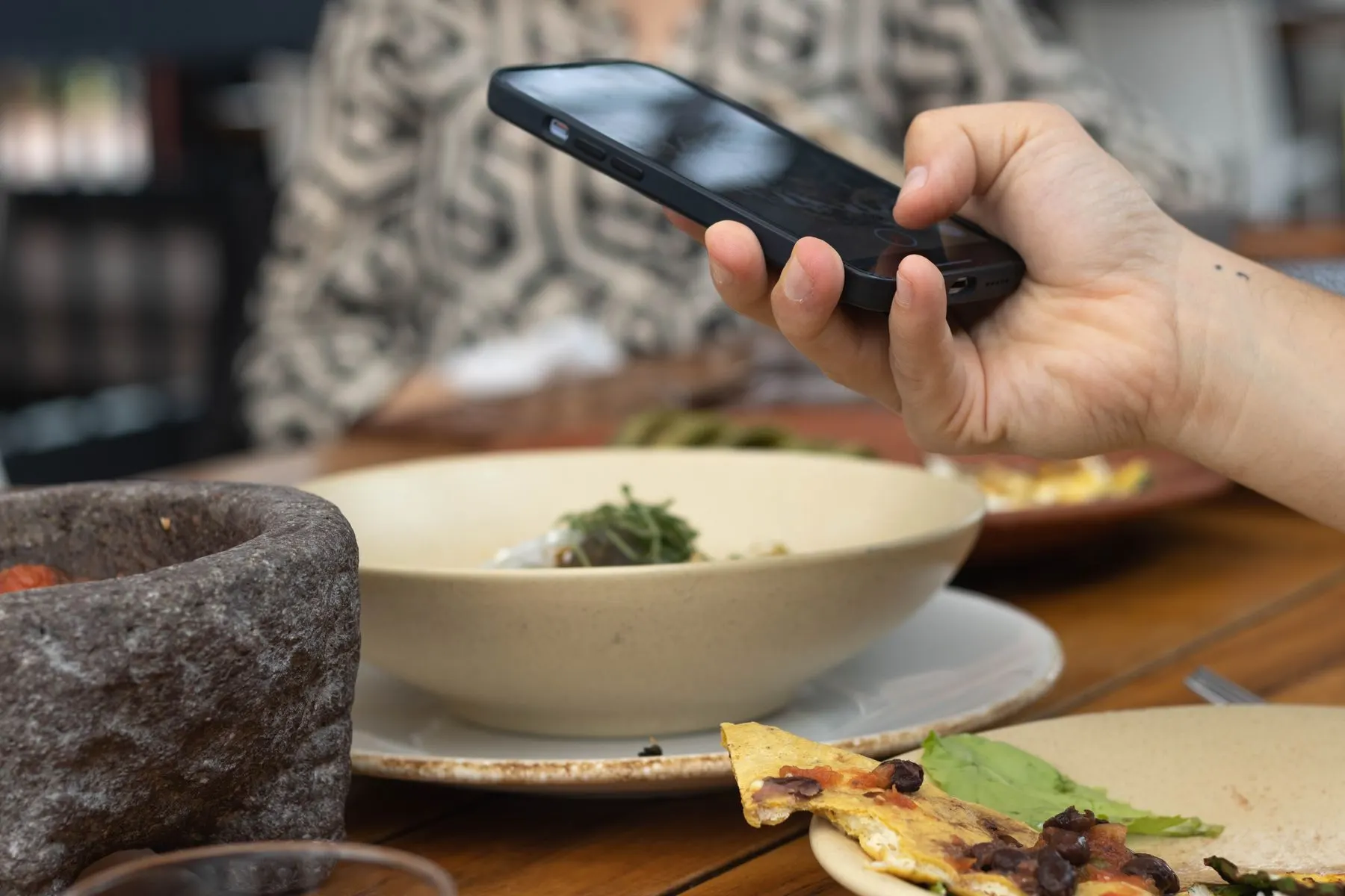 Diner using a smartphone at a restaurant table
