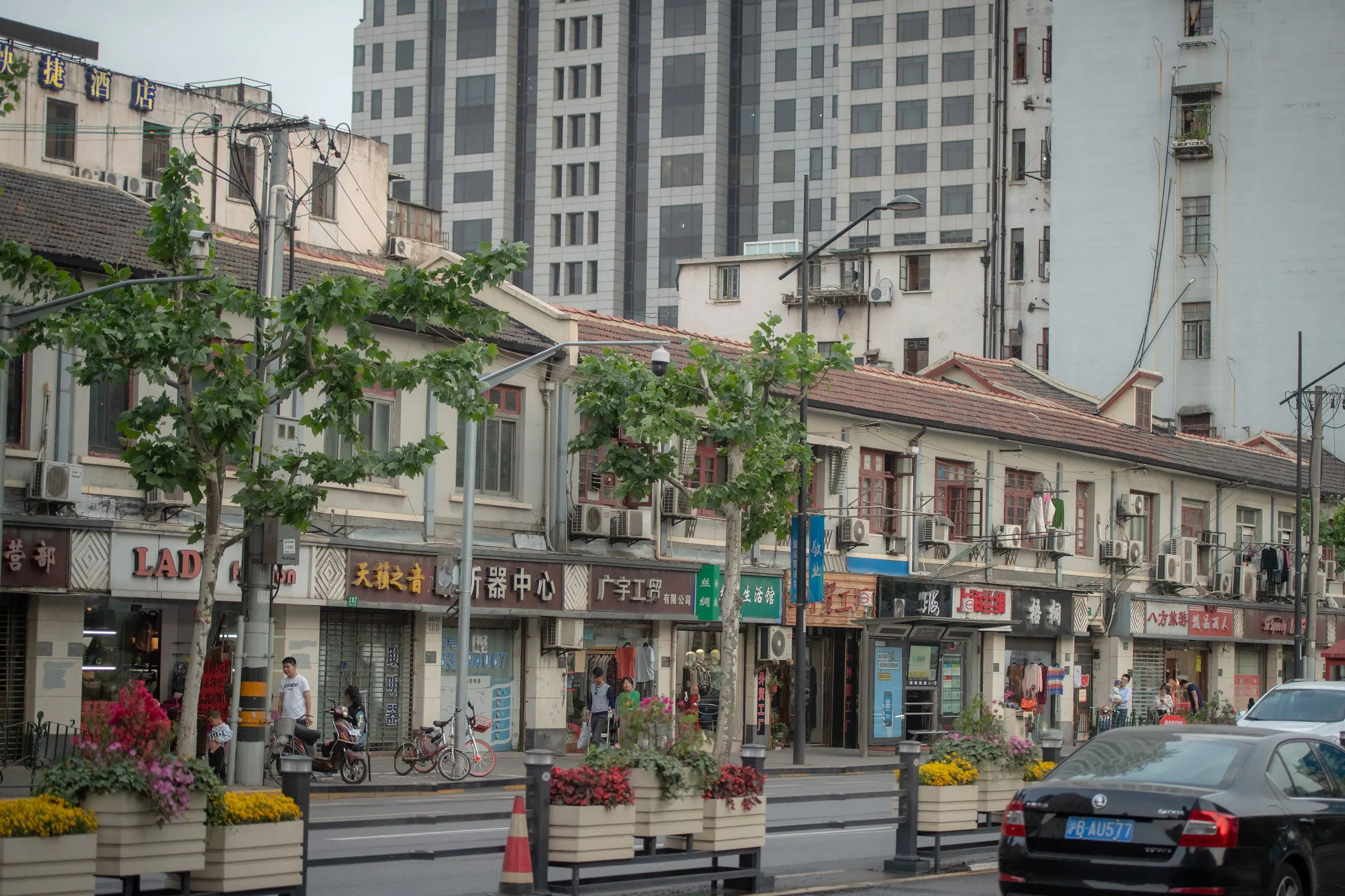 Shanghai street framed by historic storefronts and modern towers