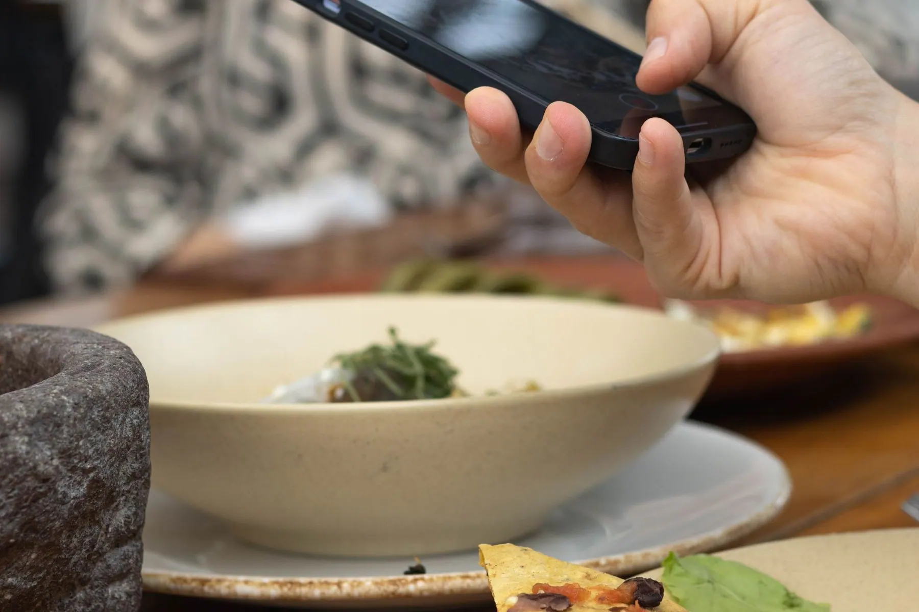 Smartphone held above a restaurant table while ordering