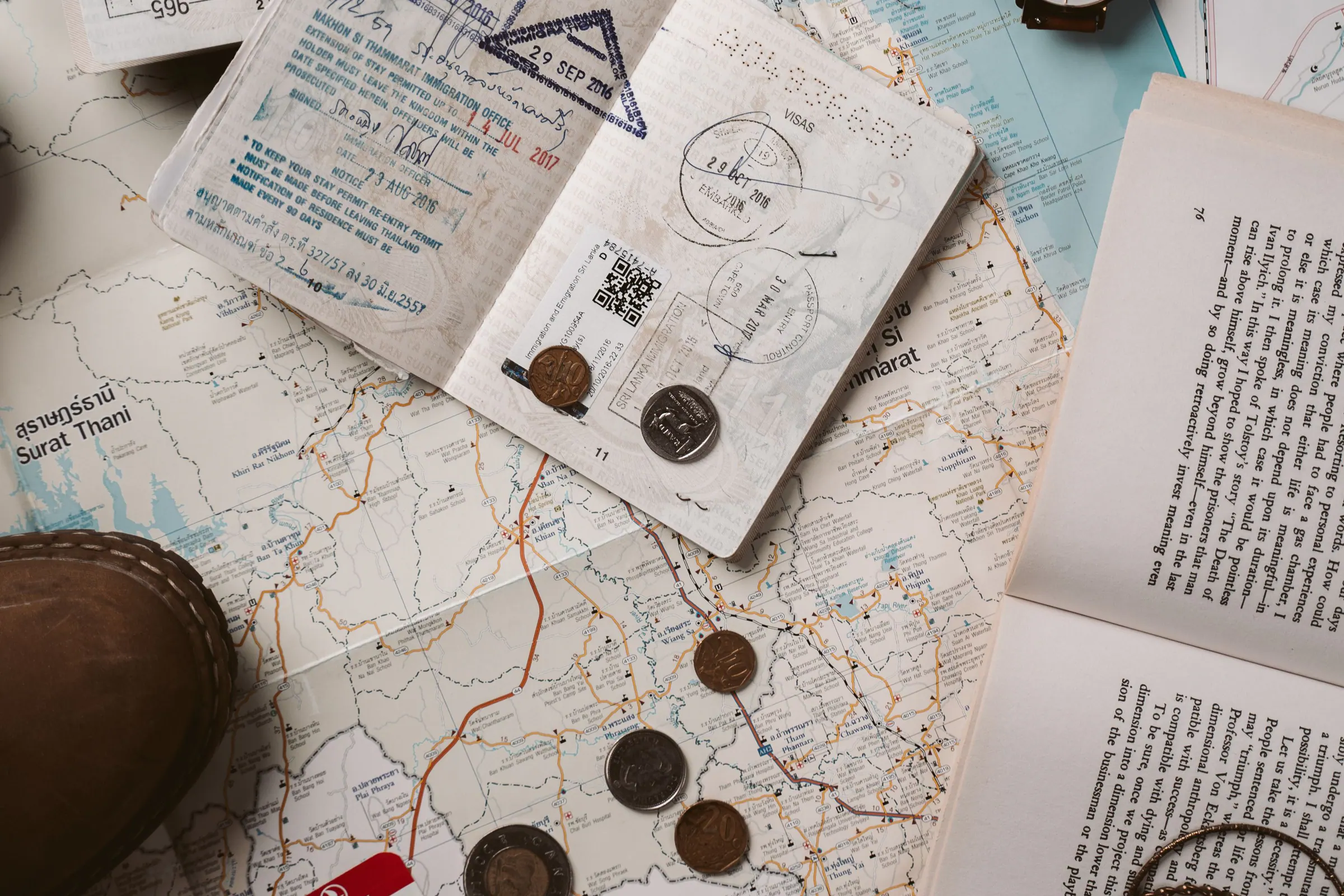 Passport, tickets, map and compact travel essentials arranged before packing