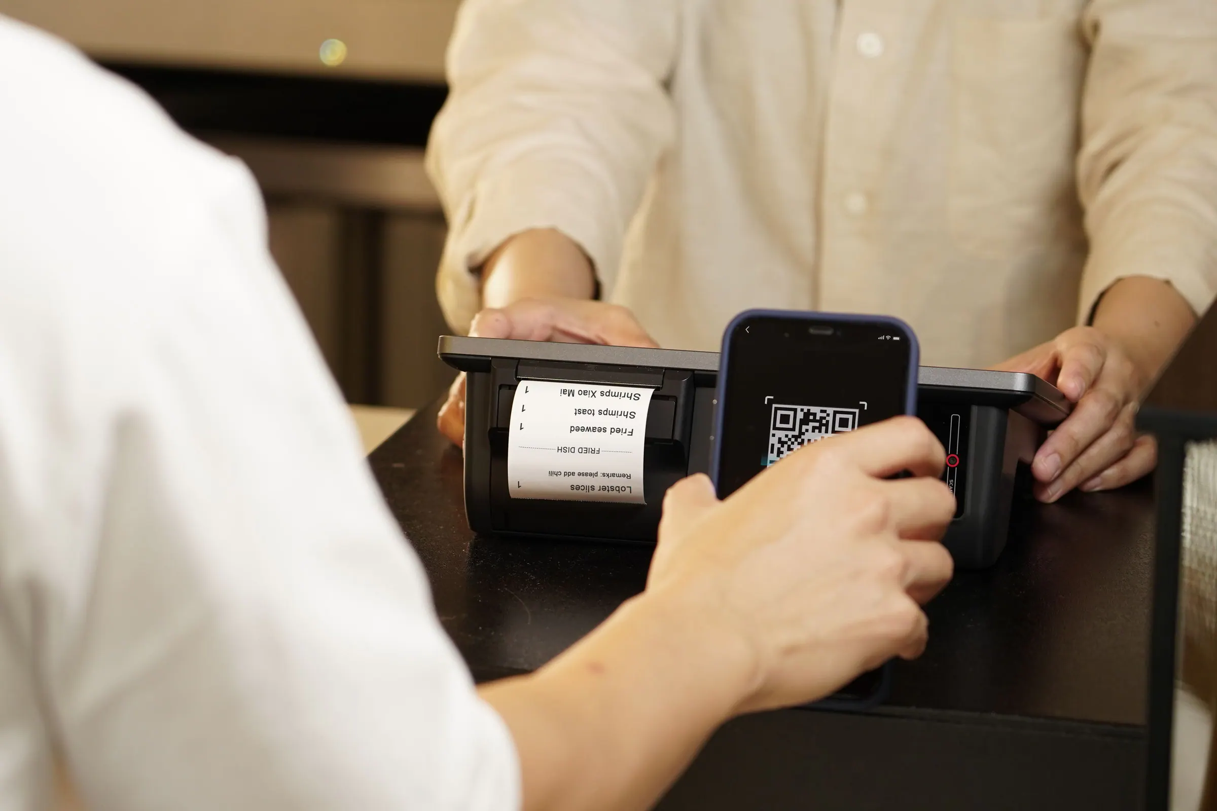 Traveler presenting a smartphone QR code at a checkout terminal