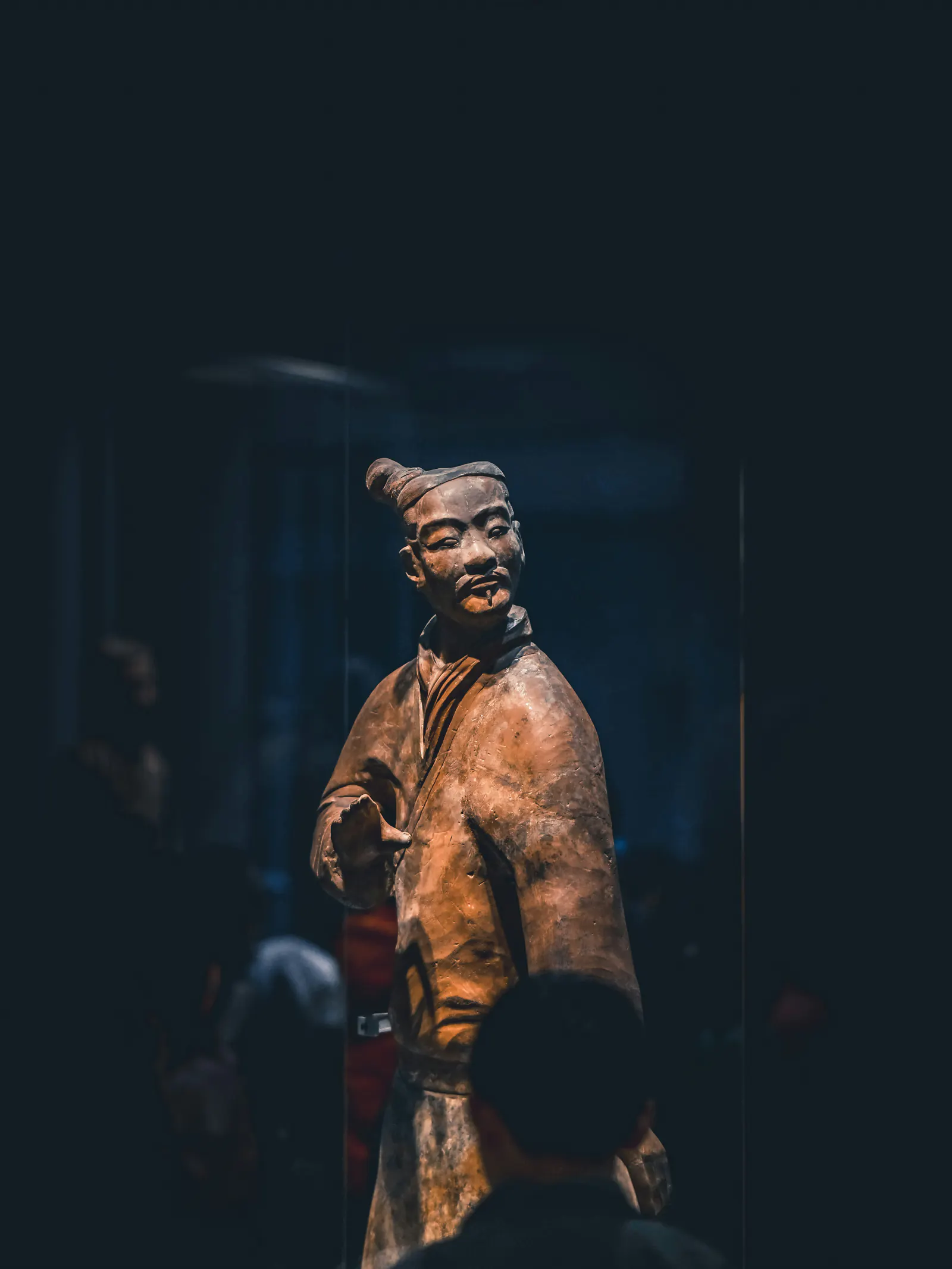 A Terracotta Warrior displayed under museum lighting in Xi'an